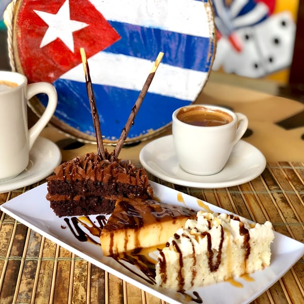 Cuban desserts: chocolate cake, flan, tres leches cake, and two cups of coffee.