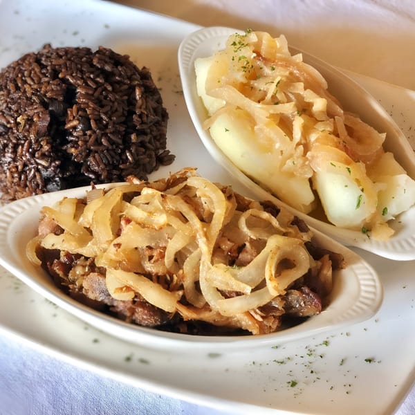 Cuban dish with black beans and rice, yuca with onions, and steak with caramelized onions.