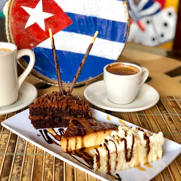 Cuban desserts: chocolate cake, flan, and tres leches cake with coffee, against a Cuban flag.