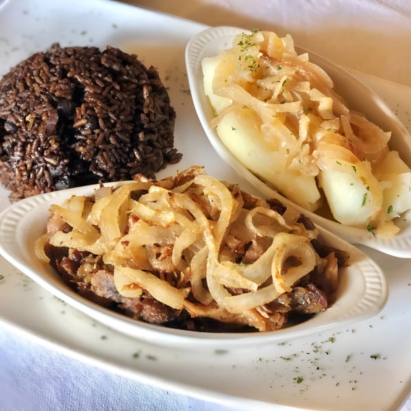 Cuban meal with black beans and rice, yuca with onions, and steak with onions.